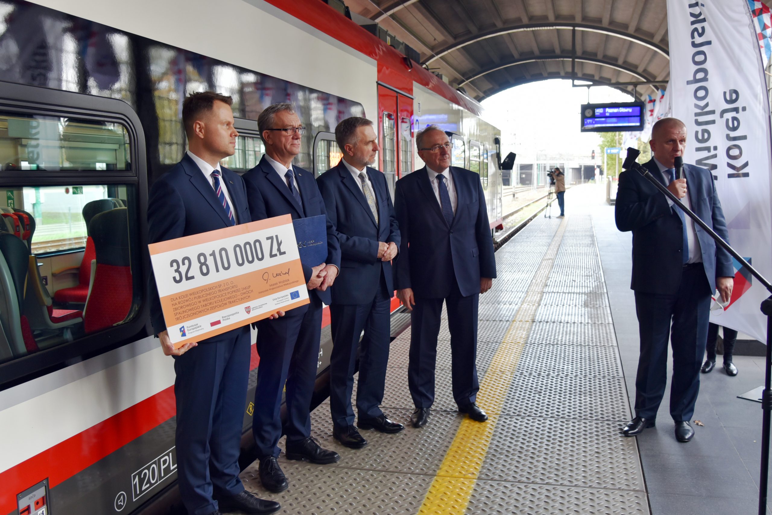 Marszałkowie, Prezesi KW oraz Prezes firmy Newag prezentują czek na realizację umowy przed pociągiem