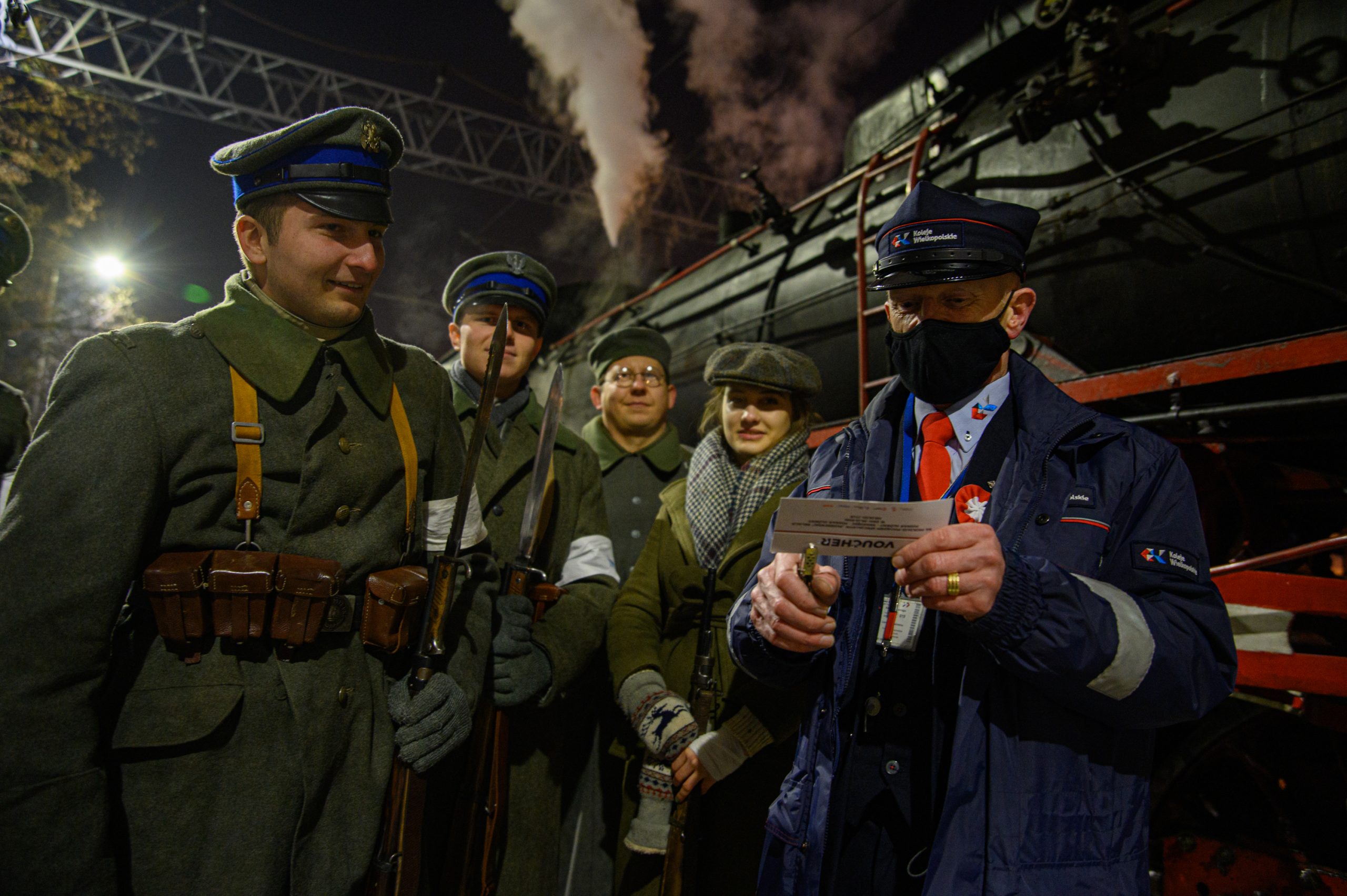Aktorzy w strojach żołnierzy wraz z kierownikiem pociągu Kolei Wielkopolskich